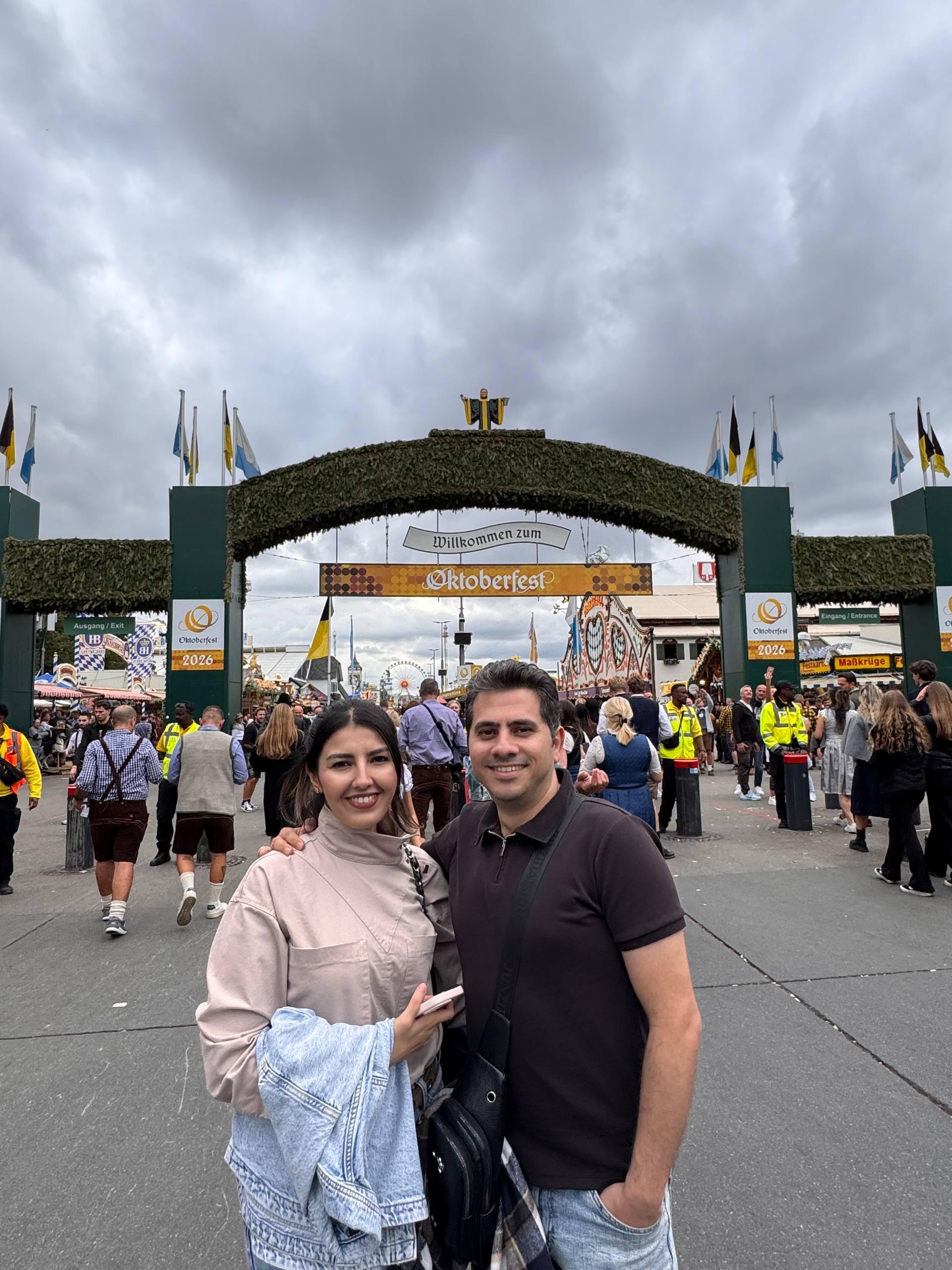 Mohammed and his wife standing under the main entrance gate of the Munich Oktoberfest