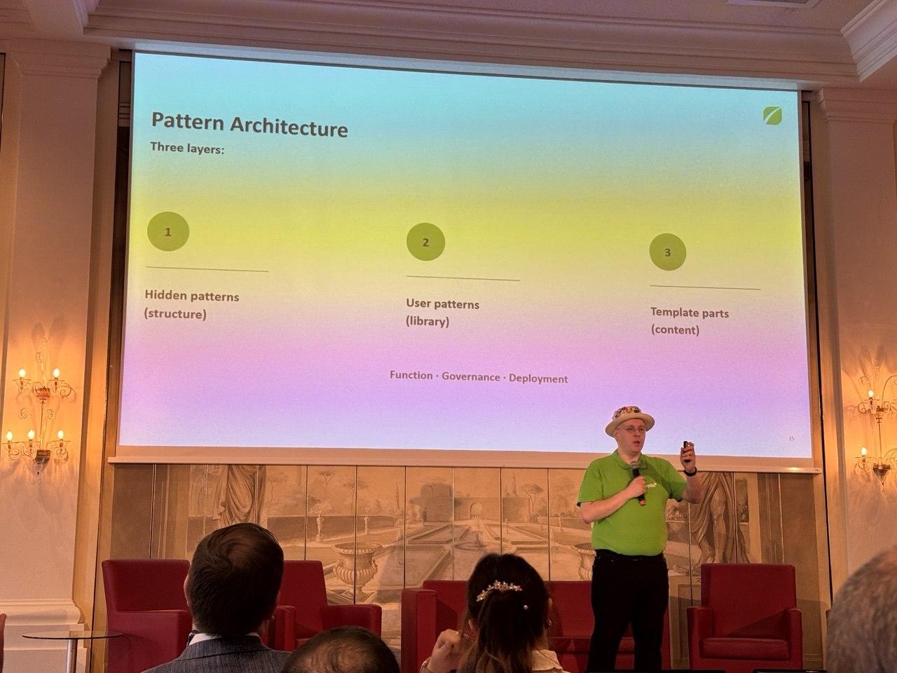 A speaker presenting a slide titled Pattern Architecture